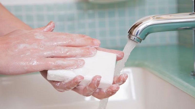 Vệ sinh bông tai bằng xà phòng và nước ấm