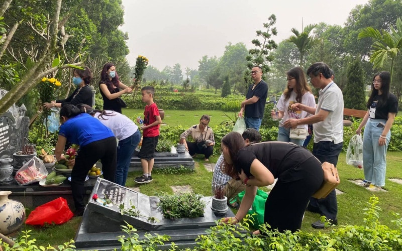 Một gia đình cùng nhau tảo mộ và thắp hương